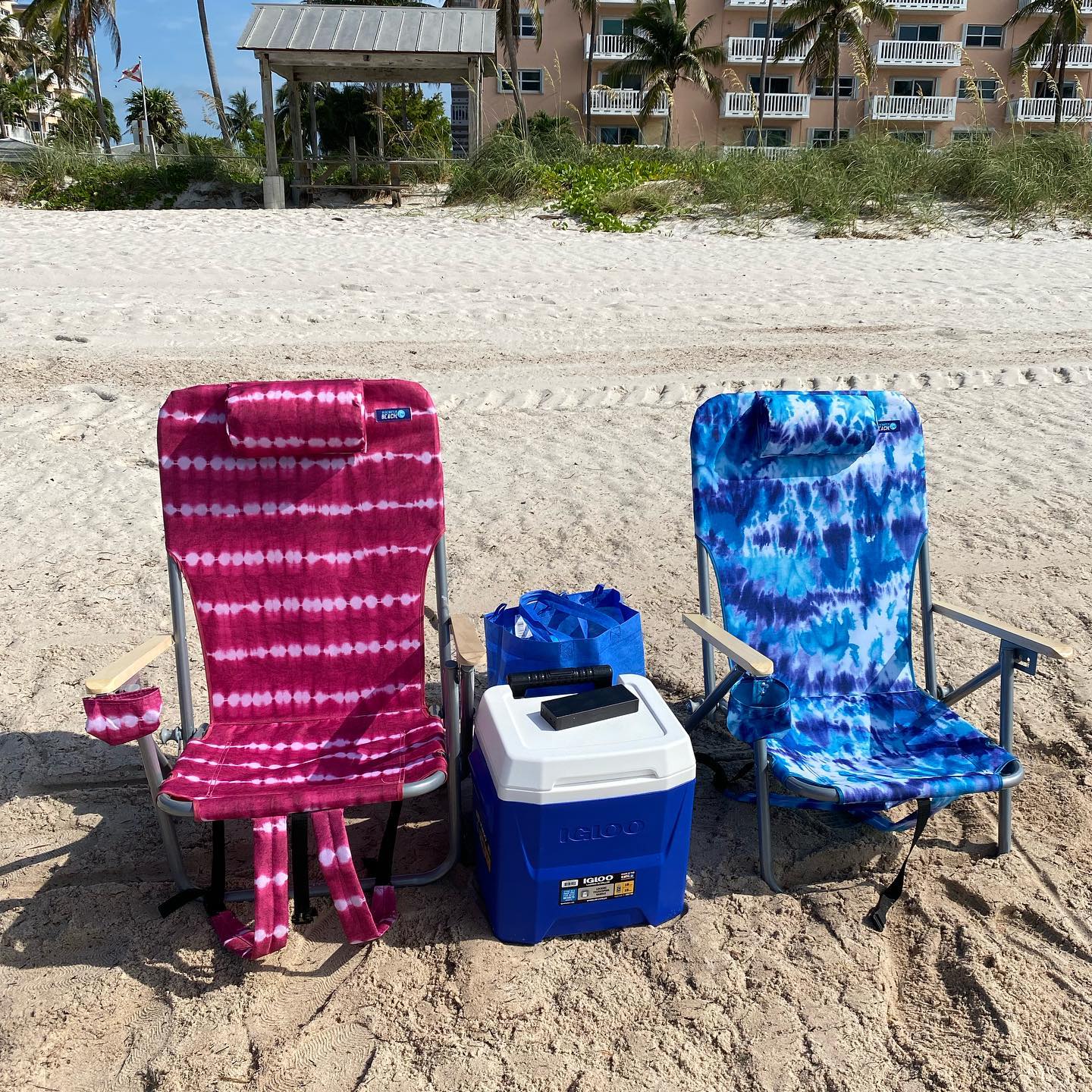 Two beach chairs and a cooler in front of a Florida condo