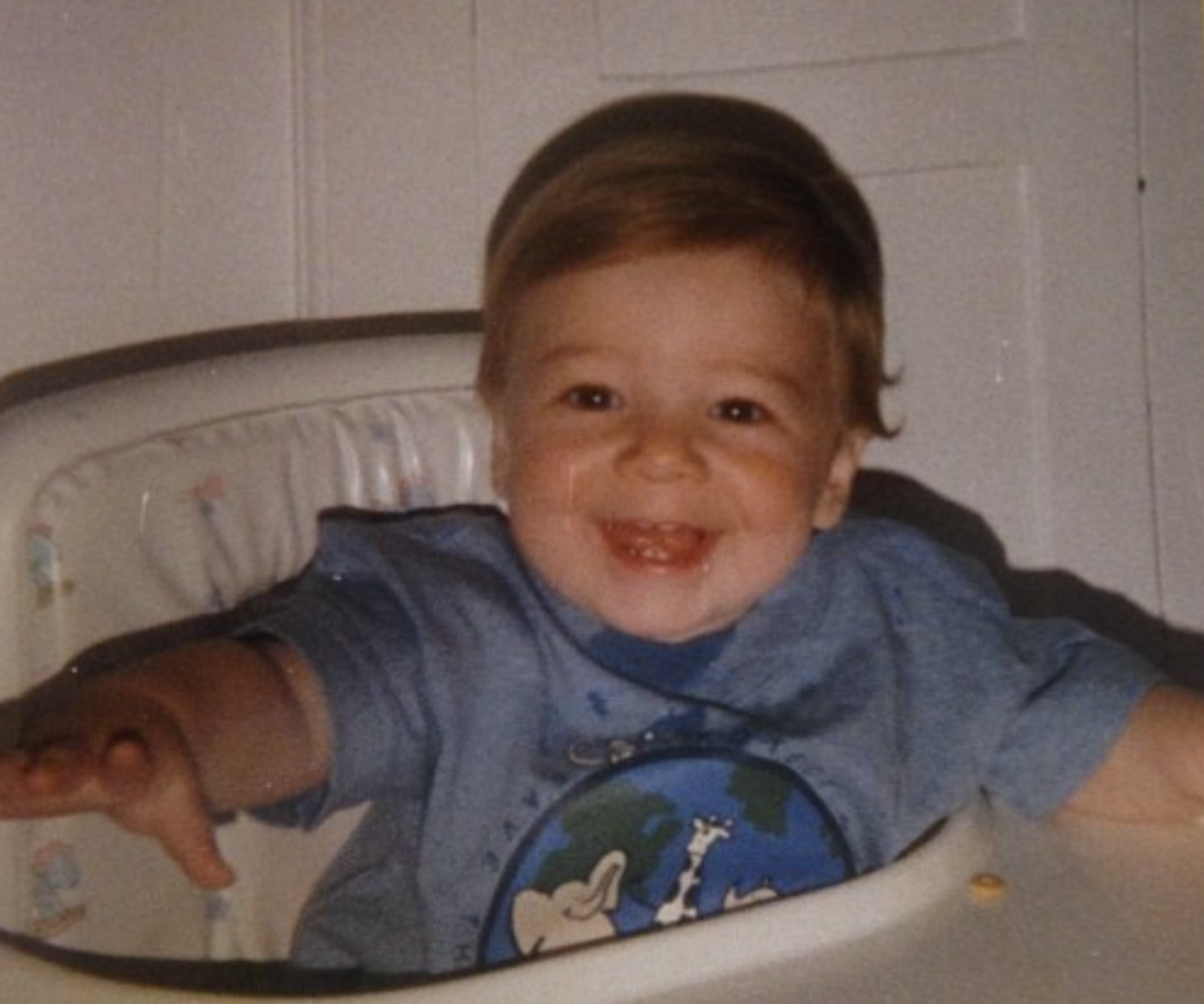 Baby Ryan in a high chair, smiling